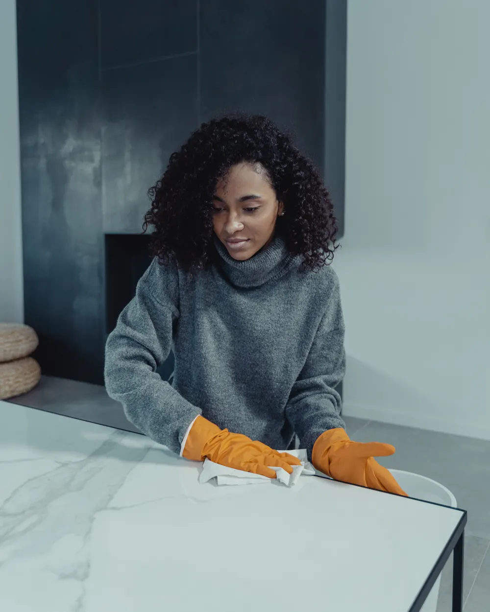 Woman in gloves deep cleaning a marble table top