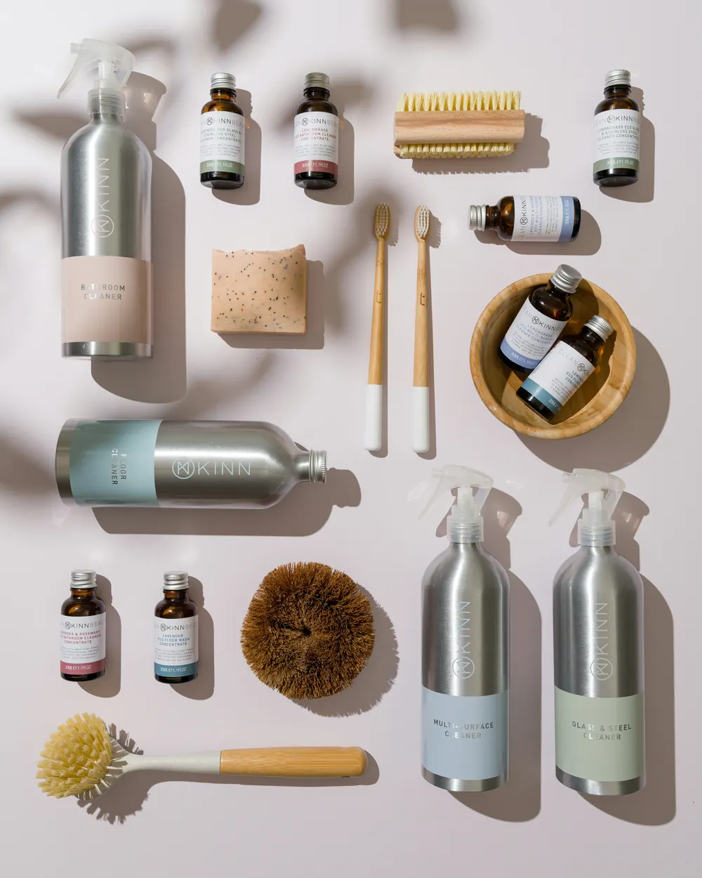 Eco-friendly cleaning products, brushes and refillable bottles laid out